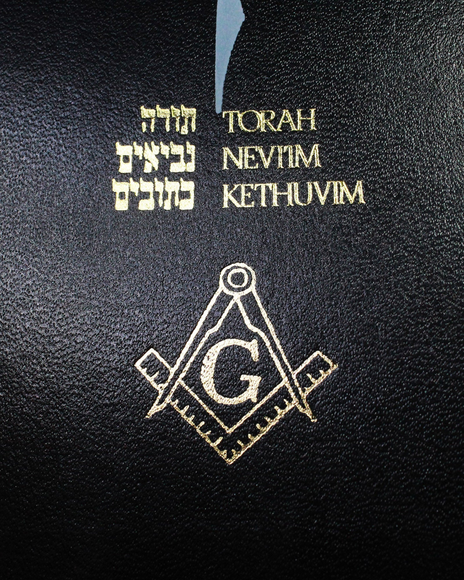 Black book cover with 'Tanakh' text and Masonic symbols on a black background